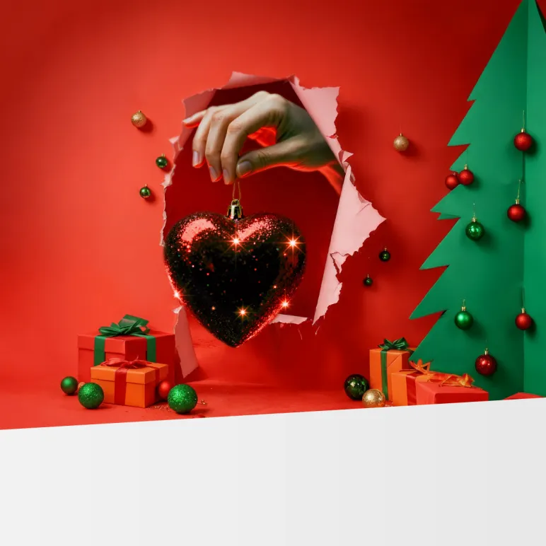 dłoń z bańką choinkową w kształcie serca 