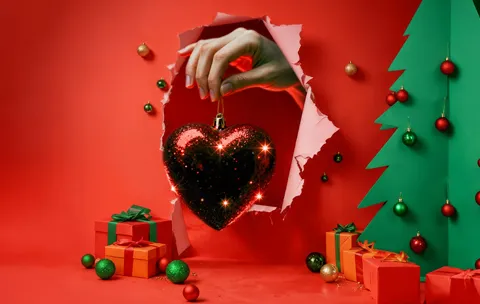 ręka trzyma bombkę w kształcie serca